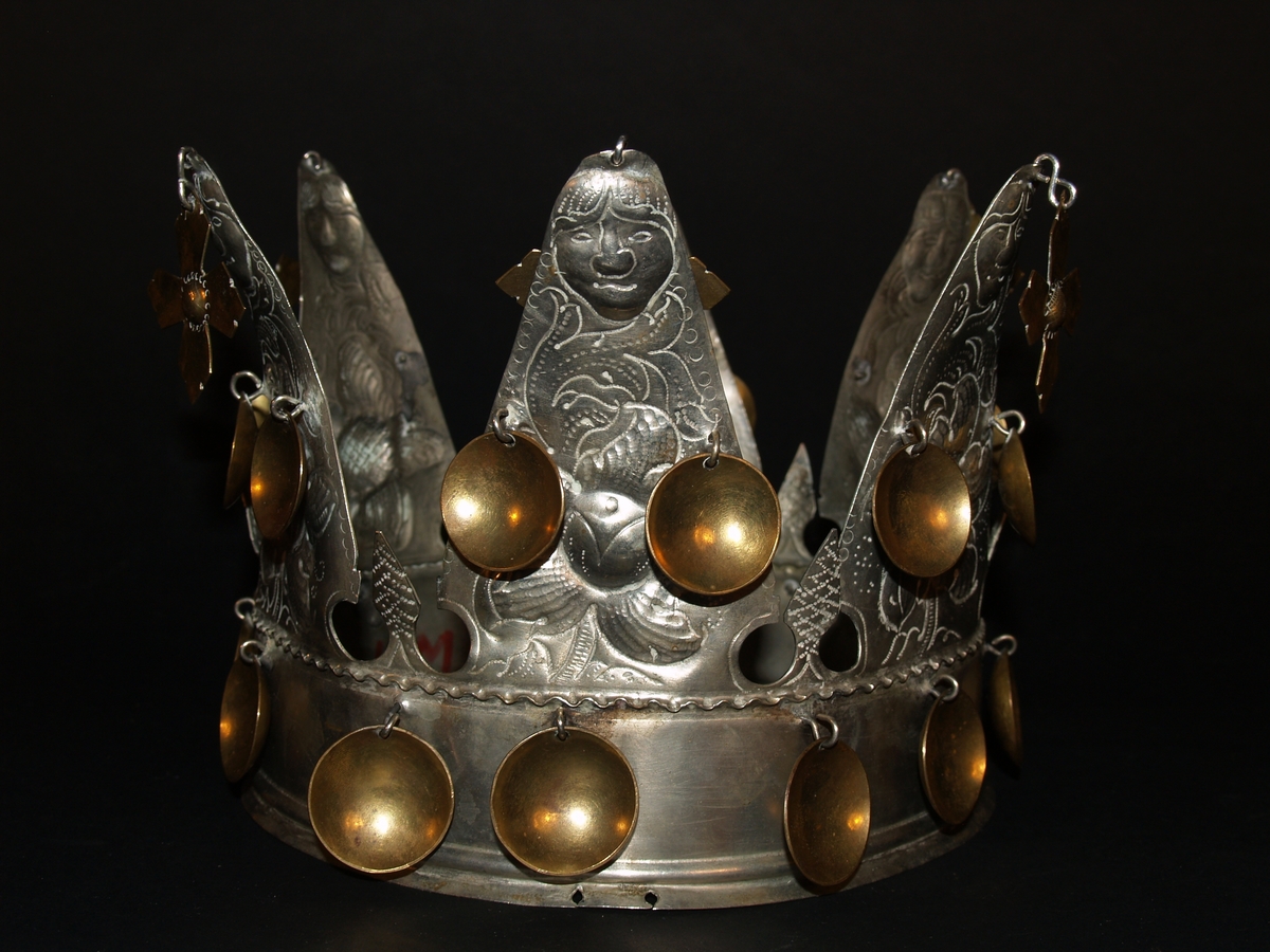 Det er ei heilrend krone, det vil seie at den er klipt/sagd ut av ei metallplate og lodda saman. Den har seks taggar og er ei open krone. Kvar tagg er dekorerte med blomemønster og i toppen er det eit ansikt, som kan tolkast som annankvar mann og kvinne. I kvar tagg er det eit heng med eit kors i messing, det er også to blad i messing halvvegs opp på kvar tagg og 12 messingblad langs med ein bøljekant nede. Under blada er det ein glatt kant utan dekor, den glatte kanten avsluttast i to bølgjer. Denne glatte kanten er vanleg på kroner og her skal det vere eit band eller eit tøystykke. I ein avisartikkelen i avisa Samhold frå 1954 er krona vår avbilda med eit tøystykke rundt, og i tilvekstprotokollen er det ført inn at krona har eit raudt fløyelsband. Dette er seinare strøket over og tøystykket er dessverre borte.