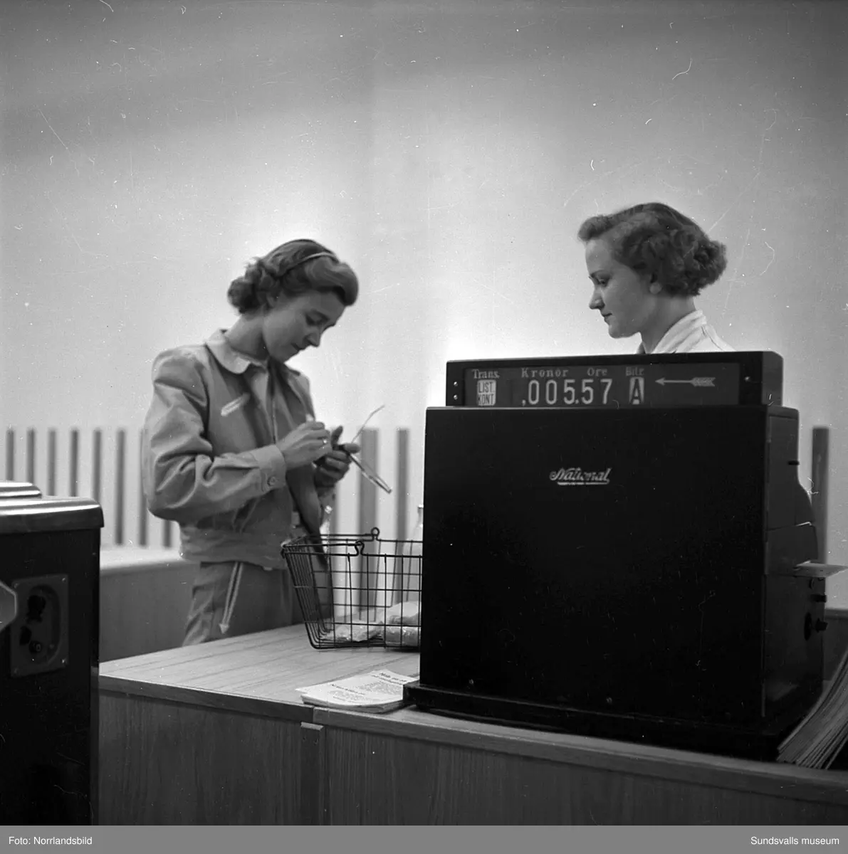 Konsums snabbköp vid Bankgatan har byggts ut 1952 och en kund är sångerskan Alice Babs som inspekterar fruktavdelningen och handlar för fem kronor och femtiosju öre.