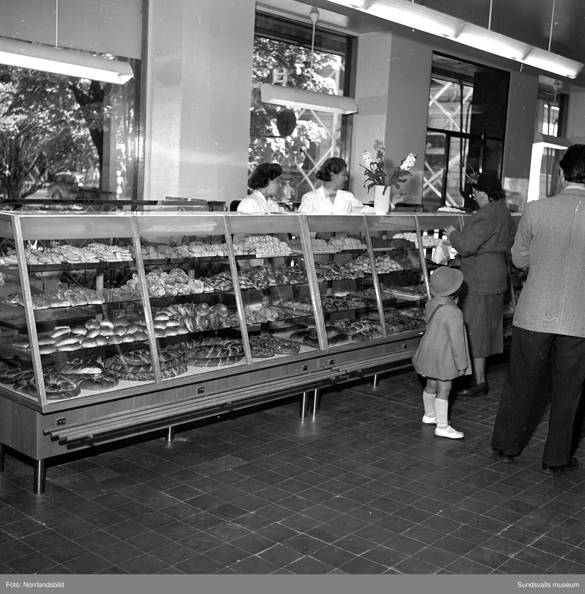 Konsums snabbköp vid Bankgatan har byggts ut 1952 och en kund är sångerskan Alice Babs som inspekterar fruktavdelningen och handlar för fem kronor och femtiosju öre.