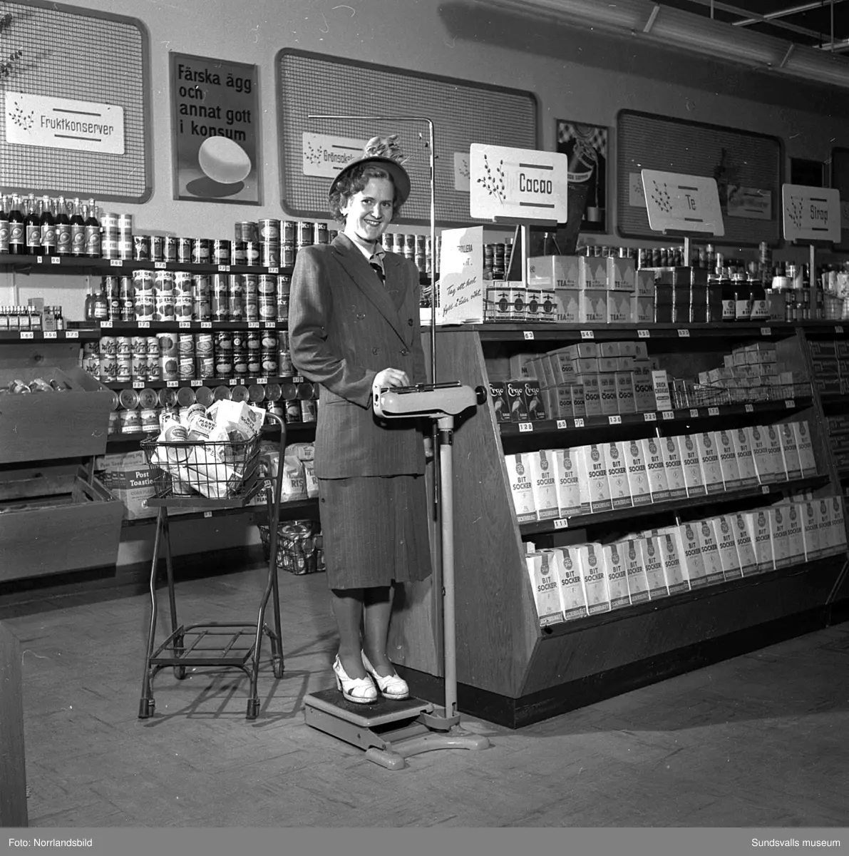 Konsums snabbköp vid Bankgatan har byggts ut 1952 och en kund är sångerskan Alice Babs som inspekterar fruktavdelningen och handlar för fem kronor och femtiosju öre.