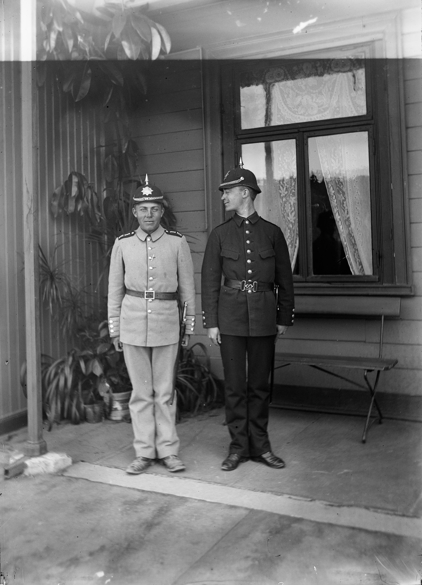 Christian Pierre Mathiesen i lys og Johan Wetlesen i mørk uniform poserer for fotografen.