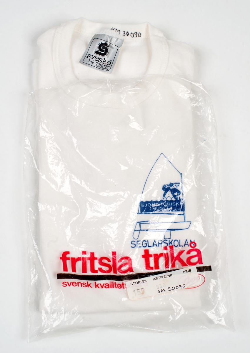 Vit t-shirt i barnstorlek 150. Tryck till vänster på bröstet: optimistjolle med sjökapten och treudd. "SJÖHISTORISKA MUSEET" i seglet samt SEGLARSKOLAN under skrovet.
