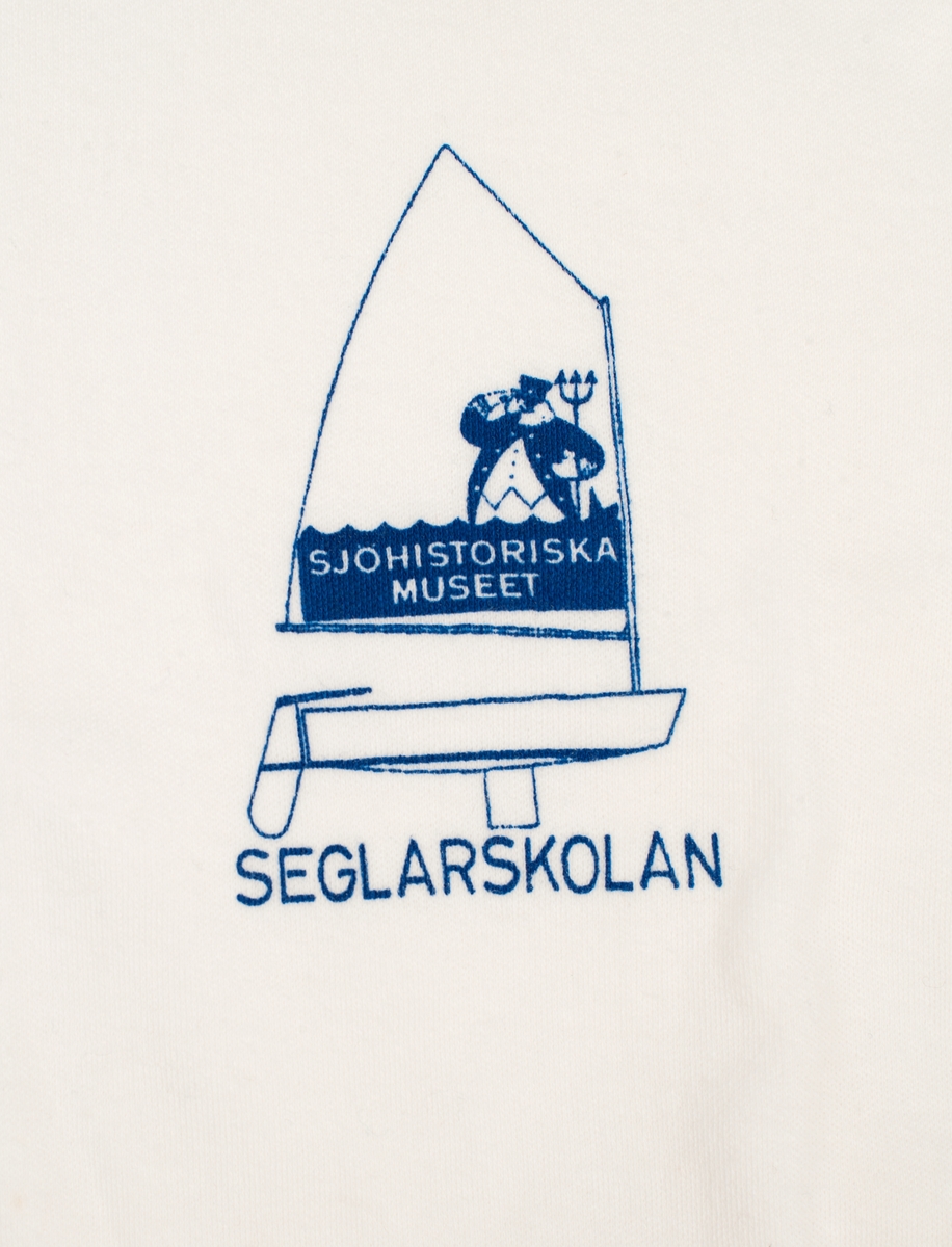 Vit t-shirt i barnstorlek 150. Tryck till vänster på bröstet: optimistjolle med sjökapten och treudd. "SJÖHISTORISKA MUSEET" i seglet samt SEGLARSKOLAN under skrovet.