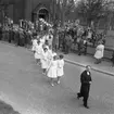 Konfirmation i Ljusnarsbergs kyrka, konfirmander, präst och människor utanför kyrkan.