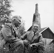 Radioinspelning i Löa, två män. Hytta i bakgrunden.