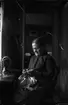 Rumsinteriör, en kvinna vid symaskinen.
Eva Sofia Pettersson (givarens farmor).