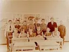 Rostaskolan, klassrumsinteriör, 13 skolbarn och lärarinna fru Dagmar Stenbeck, klass 6Ff, sal 22.
