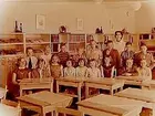 Rostaskolan, klassrumsinteriör, klass 4Aä, sal 4.
17 skolbarn och lärarinna fröken Birgitta Murgård.