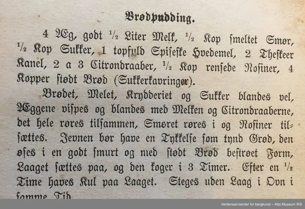 Kokebok for tarvelige husholdninger og skolekjøkkener av Antonette Baldjen. Bok med falmet og slitt omslag. Deler av boktittelen kan såvidt skimtes på bokryggen. Mellom to av bokens sider er det en presset firkløver.