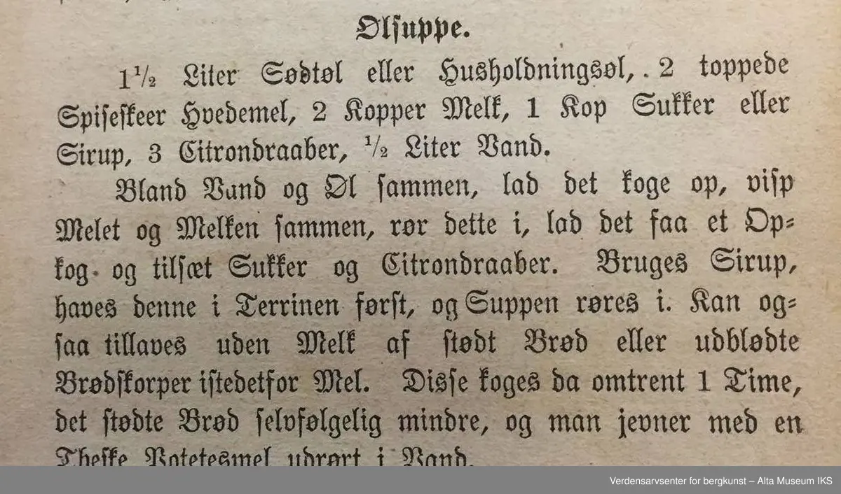 Kokebok for tarvelige husholdninger og skolekjøkkener av Antonette Baldjen. Bok med falmet og slitt omslag. Deler av boktittelen kan såvidt skimtes på bokryggen. Mellom to av bokens sider er det en presset firkløver.