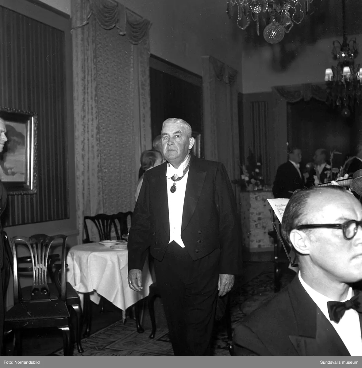 Ett urval av en stor grupp bilder från Lindgrens järnhandels 100-årsjubileumsfest på Knaust. Storstilad entré, mingel, utmärkelser, galamiddag och dans. Underhållning av bland annat en mycket ung Ingeborg Nyberg. På bilderna syns bland annat direktör Fridolf Brunnzell och lagerchefen Carl "Spiken" Lundberg, vilken samma år firade 50 år som anställd vid företaget.
