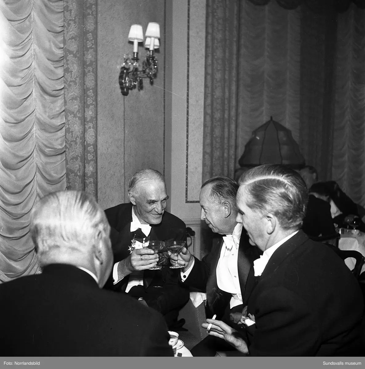 Ett urval av en stor grupp bilder från Lindgrens järnhandels 100-årsjubileumsfest på Knaust. Storstilad entré, mingel, utmärkelser, galamiddag och dans. Underhållning av bland annat en mycket ung Ingeborg Nyberg. På bilderna syns bland annat direktör Fridolf Brunnzell och lagerchefen Carl "Spiken" Lundberg, vilken samma år firade 50 år som anställd vid företaget.