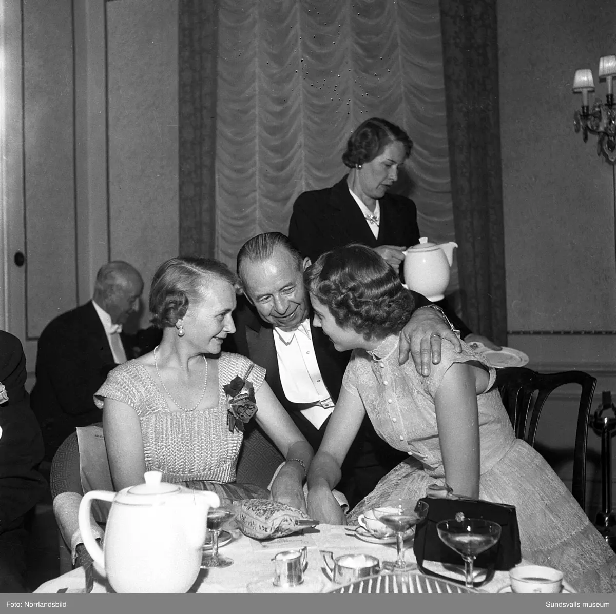 Ett urval av en stor grupp bilder från Lindgrens järnhandels 100-årsjubileumsfest på Knaust. Storstilad entré, mingel, utmärkelser, galamiddag och dans. Underhållning av bland annat en mycket ung Ingeborg Nyberg. På bilderna syns bland annat direktör Fridolf Brunnzell och lagerchefen Carl "Spiken" Lundberg, vilken samma år firade 50 år som anställd vid företaget.
