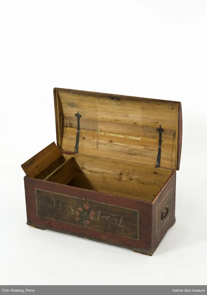 KLM 45384. Kista. Furu, järn. Kista med kupat lock och sinkade hörn. Bandgångjärn på insidan av locket och på baksidans utsida. På båda kortsidorna finns bärhandtag av smidesjärn. På fronten syns spår av en oval nyckelskylt, som nu ärborta. Lås saknas. Kistan står på fötter som är kraftigt nedslitna. Kistan är utvändigt bemålad med rödbrunt  ådringsmålat ramverk kring ekådrade fyllningar. Fronten är målad med initialerna J.G.S, årtalet 1831 i vitt, samt en blomsterslinga med sju blommor i rött. Baksidan är  enfärgad i rödbrunt. Inne i kistan finns på vänstra sidan en läddika med med ett lock målat i rödbrunt. I övrigt är kistan omålad invändigt.