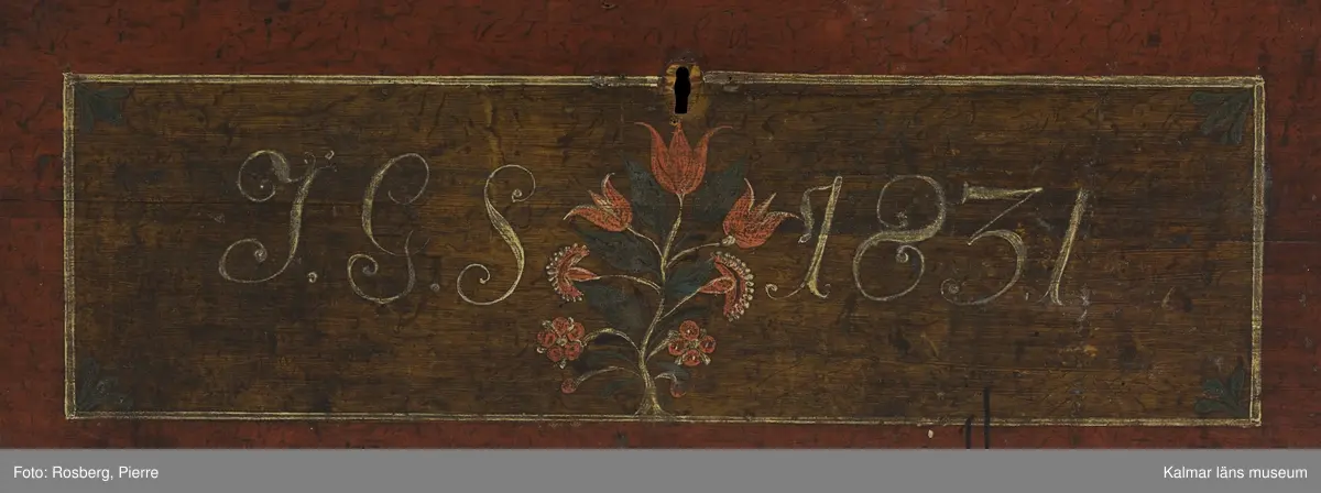 KLM 45384. Kista. Furu, järn. Kista med kupat lock och sinkade hörn. Bandgångjärn på insidan av locket och på baksidans utsida. På båda kortsidorna finns bärhandtag av smidesjärn. På fronten syns spår av en oval nyckelskylt, som nu ärborta. Lås saknas. Kistan står på fötter som är kraftigt nedslitna. Kistan är utvändigt bemålad med rödbrunt  ådringsmålat ramverk kring ekådrade fyllningar. Fronten är målad med initialerna J.G.S, årtalet 1831 i vitt, samt en blomsterslinga med sju blommor i rött. Baksidan är  enfärgad i rödbrunt. Inne i kistan finns på vänstra sidan en läddika med med ett lock målat i rödbrunt. I övrigt är kistan omålad invändigt.