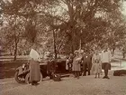 Kvinnor, män och barn vid en bil. 
Bilen som skymtar på bilden är en Dodge från cirka 1920.