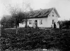 Bostadshus i Lilla Lisätter, efter tromb (se taket).
Familjegrupp framför huset.