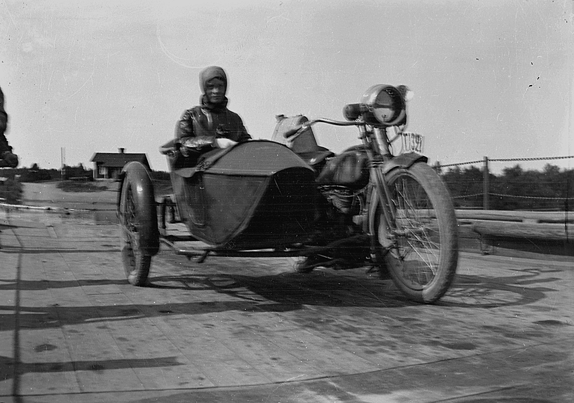 En kvinna på motorcykel.
Dalarna.
Motorcykeln är en Reading Standard som registrerades 20:e juni 1921 och ägdes av Karl Erik Hedström, Örebro.