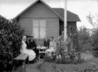 Örebro kolonien.
Bostadshus, fem personer vid kaffeborddet, framför huset.