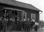 Uppställning framför en stuga. Familjen Nilsson (Nilsén) från Kolja, 
Rinkaby sn?.Bilden är inte tagen i Kolja. Bl.a. landshövding Hasselrot i uniform.