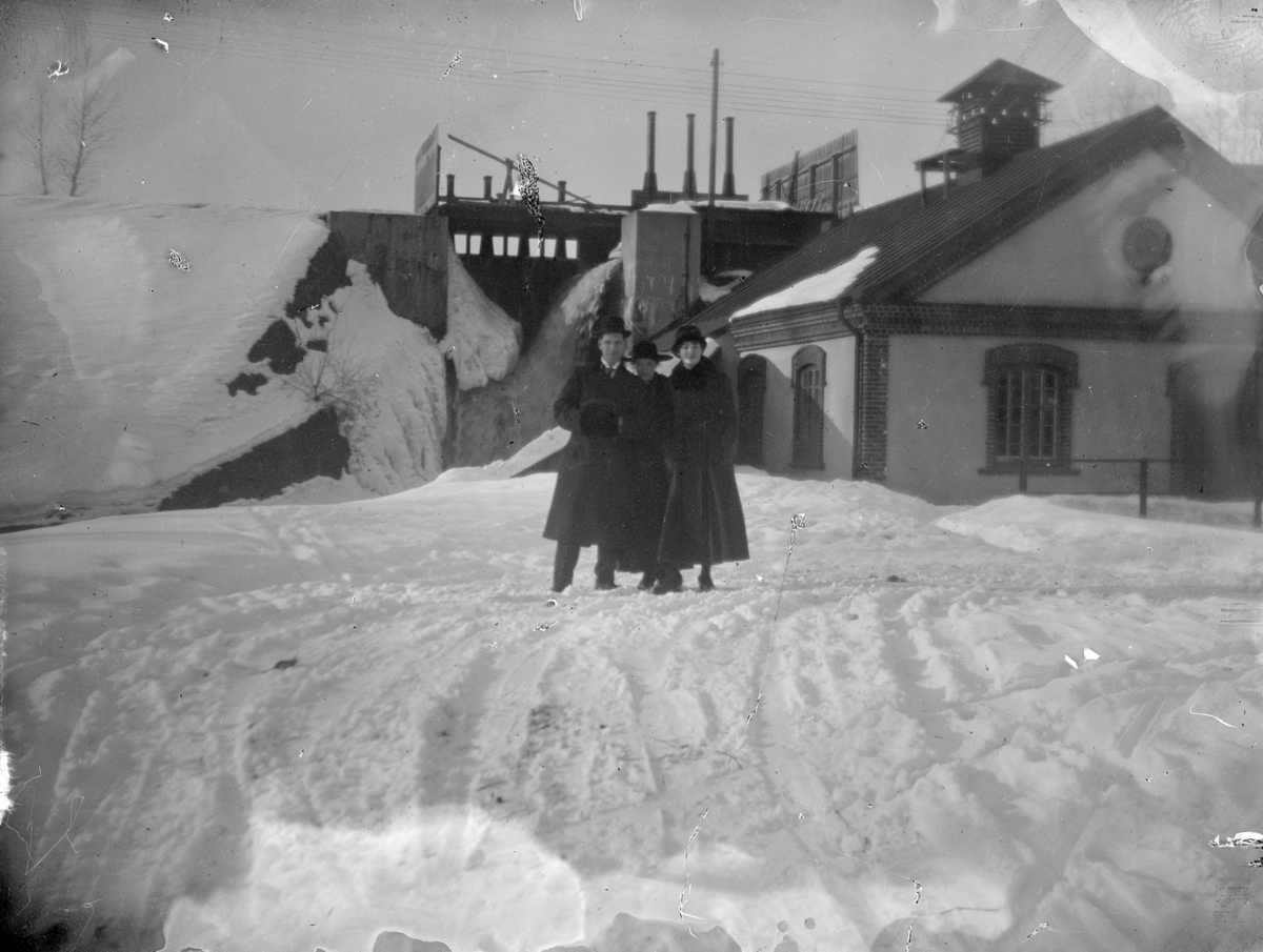 Karl Hedström och två kvinnor. 
Kraftstationen i bakgrunden.