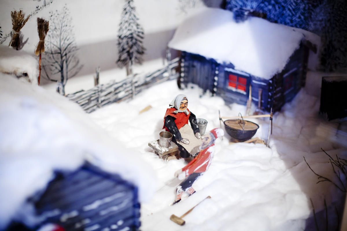 Mekanisk juleutstilling med figurer nissefar og nissemor utenfor et hus.