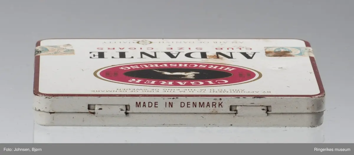 Oval logo på lokket: hjort i sprang
