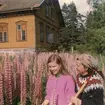 Bystad skola.
Vid köpet år 1966 var trädgården helt förvildad och igenvuxen av lupiner. Eftersom familjen tillträdde huset först i december 1966 bör dessa bilder vara tagna sommaren 1967, då givarens föräldrar började röja utomhus. Personerna på bilderna är givaren Maria Szewczyk (senare gift Wistrand) och hennes mor Inga Szewczyk.