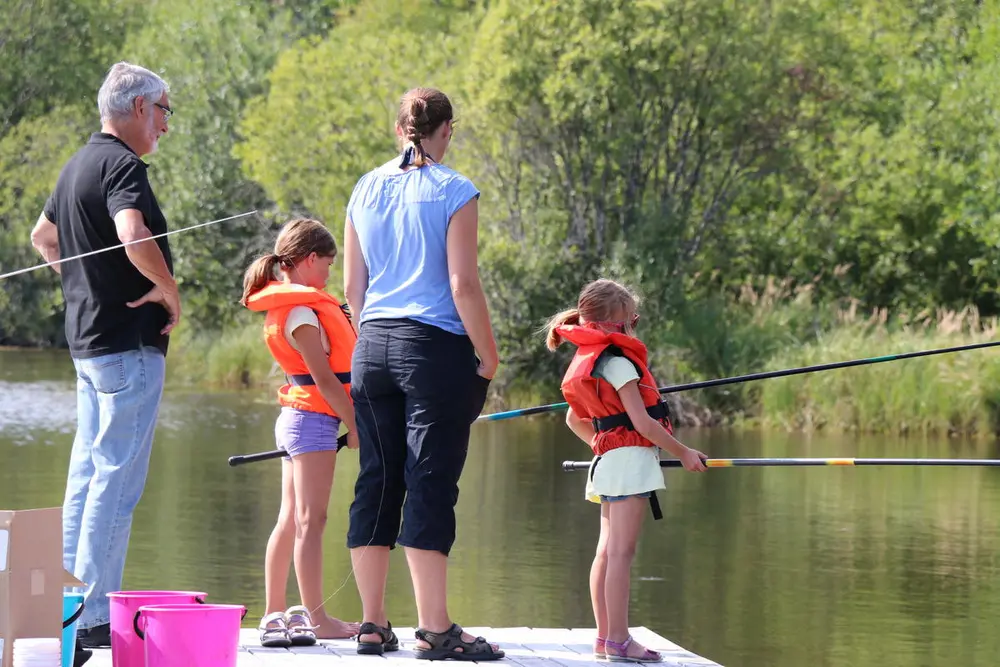 Foto av en familie som står og fisker
