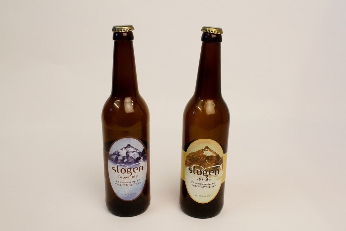 Begge flaskene er av brunt glas og med volum innhald på 0,5 liter.
To typar Slogen øl; Slogen lys ale med gul etikett og Slogen brown ale med lys blå etikett. Begge med motiv av fjellet Slogen på etiketten.