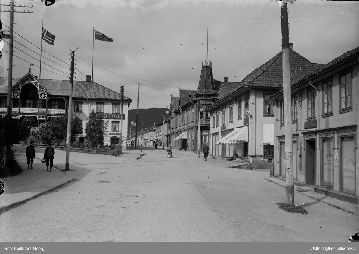 Kongsberg, Storgata i Kongsberg. Magasingaten går opp til venstre foran hotellet. I dag heter gaten Tinius Olsens gate.
Til venstre Grand hotel.