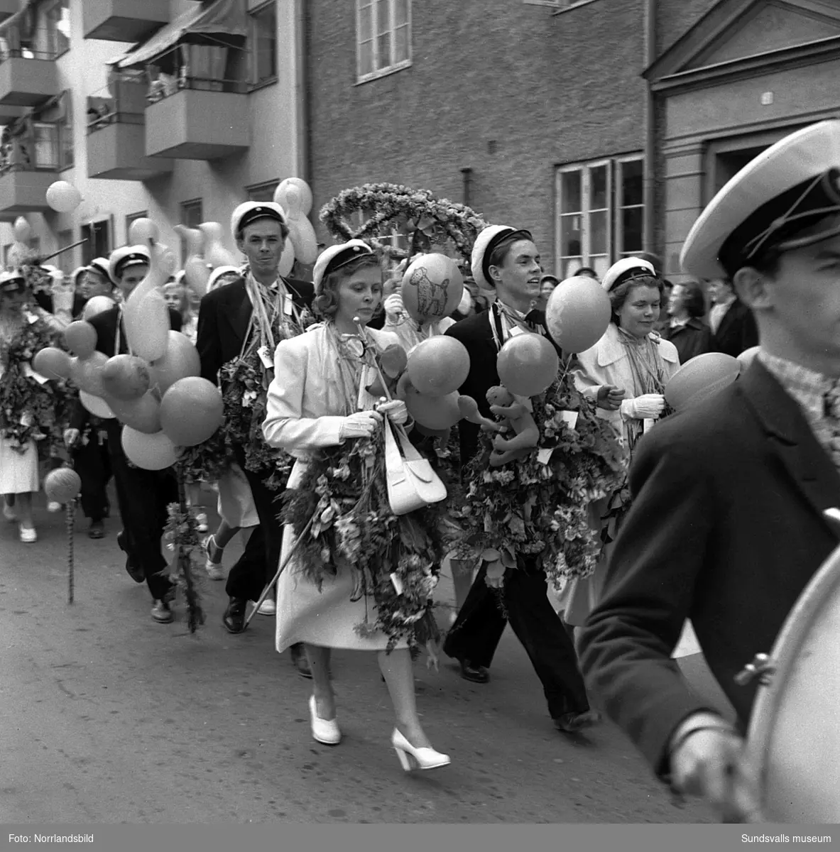 Studentexamen 1951. Studenterna på läroverkets trappa och tågandes utefter Köpmangatan mot stora torget.