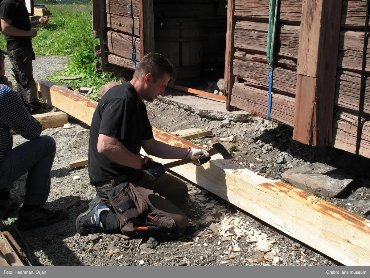 Siggebohyttans bergsmansgård, kurs och renoveringsarbeten vid smedjan (Nora Siggebohyttan 2:2).
Reparationsarbete på smedjans grund och timmerstomme, hösten 2011 och vår, sommar, höst 2012.
Den nya syllstocken placeras in.
Dnr: 2007.600.373