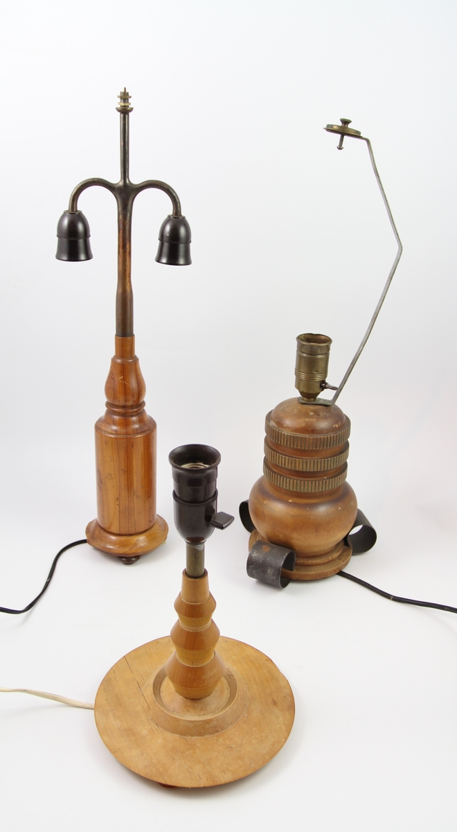 Tre elektriske bordlamper designet av Thilo Schoder. A: Høy smal fasong, fire små føtter, høy smal hoveddel, støpsel til to lyspærer i nedad hengende retning, spir på toppen trolig til feste av lampeskjerm B: Tre føtter i smijern kommer ut på siden, robust hoveddel med malt vertikal dekor i fordypninger i treverket. Lang metalldel på toppen, trolig til eventuell lampeskjerm, feste til en lyspære i hoveddelen. C: Fire små bein, bred bunn, bulket smal stake opp til lyspærefestet. Trolig tiltenkt lampeskjerm festet direkte på lyspæren. Ledning fra bunnen i alle tilfeller.