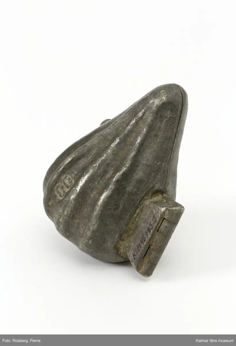 KLM45785:5 Form, av tenn. Form för att gjuta dekorationer i glass. Frukt men oklart vilken. Päron?. På båda sidor stämplad med CC., för företaget Cadot et Cie, Frankrike.