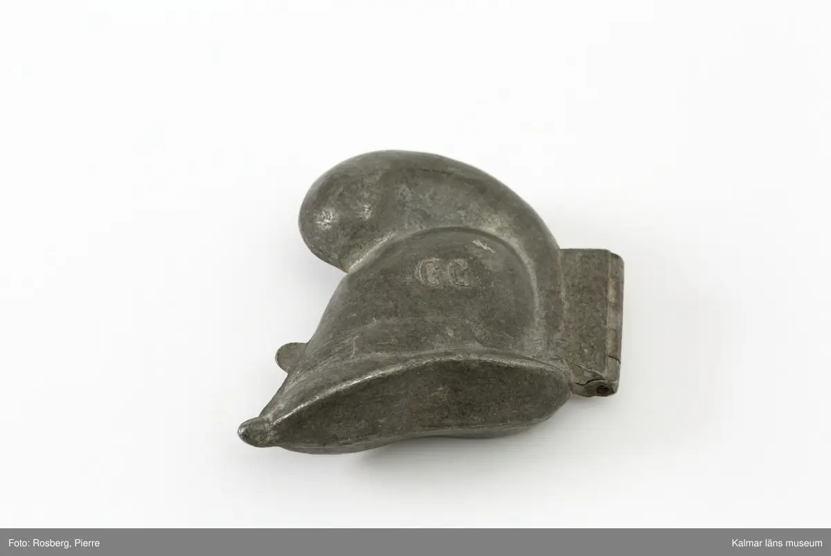 KLM45785:8. Form. Av tenn. Form för att gjuta dekorationer av glass. Romersk hjälm med plym. Plymen något skadad. På båda sidor stämplad med CC., för företaget Cadot et Cie, Frankrike.