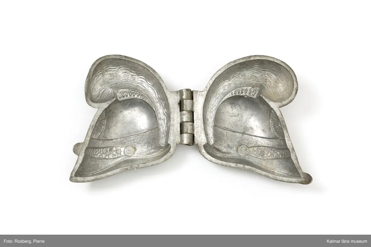 KLM45785:8. Form. Av tenn. Form för att gjuta dekorationer av glass. Romersk hjälm med plym. Plymen något skadad. På båda sidor stämplad med CC., för företaget Cadot et Cie, Frankrike.