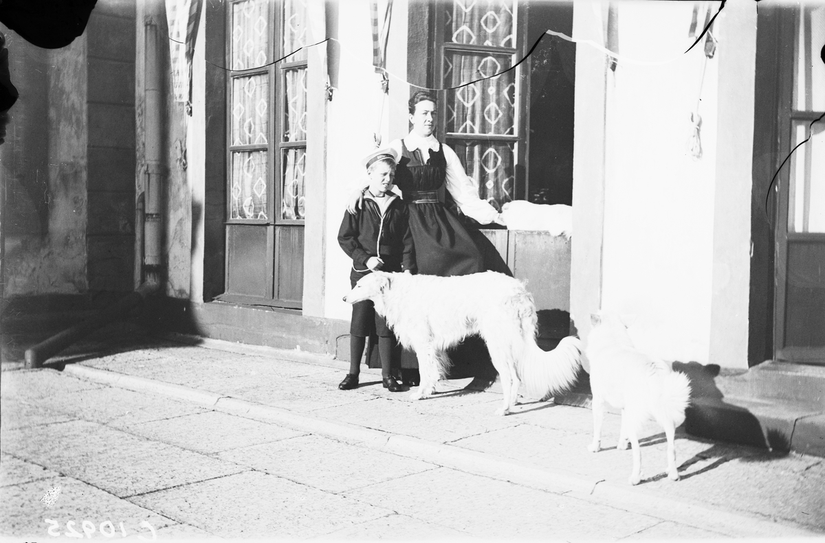 Drottning Victorias bilder. Drottning Victoria i Tullgarnsdräkt, med prins Erik och två hundar på Tullgarns slott.
