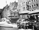 Skioptikonbild med motiv marknadsstånd på torget i Nürnberg, bredvid fontän.
Bilden har förvarats i kartong märkt: Nürnberg 1901. V.