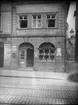 Skioptikonbild med motiv av butik längs gatan Lange Strasse i Bamberg.
Bilden har förvarats i kartong märkt: Resan 1907. Eisenach 5. Bamberg 7. 18. Text på bild: 