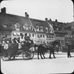 Skioptikonbild med motiv av stort hästekipage på Hans Sachs Plats i Nürnberg.
Bilden har förvarats i kartong märkt: Resan 1907. Bamberg 2. Nürnberg 6. 295.. Text på bild: 