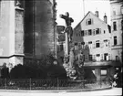 Skioptikonbild med motiv av staty med jesus på korset, utanför kyrka i Stuttgart.
Bilden har förvarats i kartong märkt: Resan 1908. Stuttgart 1.