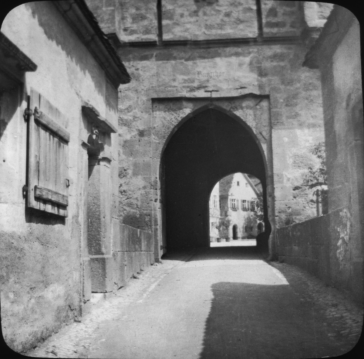 Skioptikonbild med motiv av port genom Röder Thor, passage genom stadsmuren, Rothenburg.
Bilden har förvarats i kartong märkt: Rothenburg I. 1901. Text på bild: "Rothenburg a.d. Röder Thor 1901".