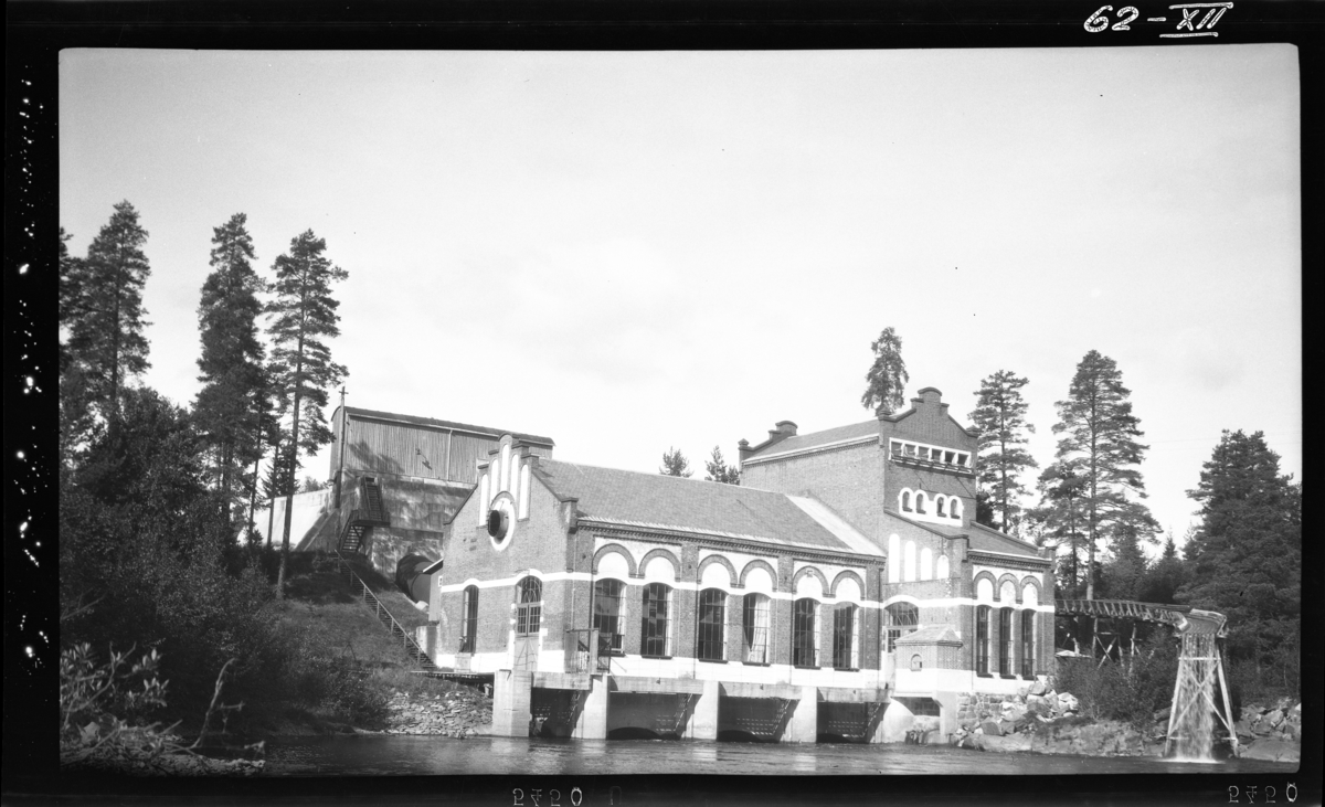 Ca. 7 km. nedenfor Kongsberg. "Brukseierforeningens fastmerke" helt ytterst til høyre. Flommerke 1927 skal være på veggen mot venstre, i form av en messinplate.