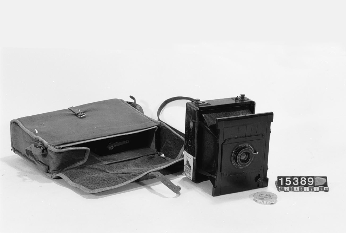 Klappkamera med ridåslutare, för plåtar 9 x 12 cm. Kassettens mått: 60 x 110 x 175,  vikt: 0,5 kg. Med stativ, kassetter och väska.
Tillbehör: Kamera, 3 st. dubbelkassetter, plåtväxelkassett med 12 st. plåthållare, rullfilmskassett, rörstativ av aluminium, väska, stativ samt fodral till stativet.