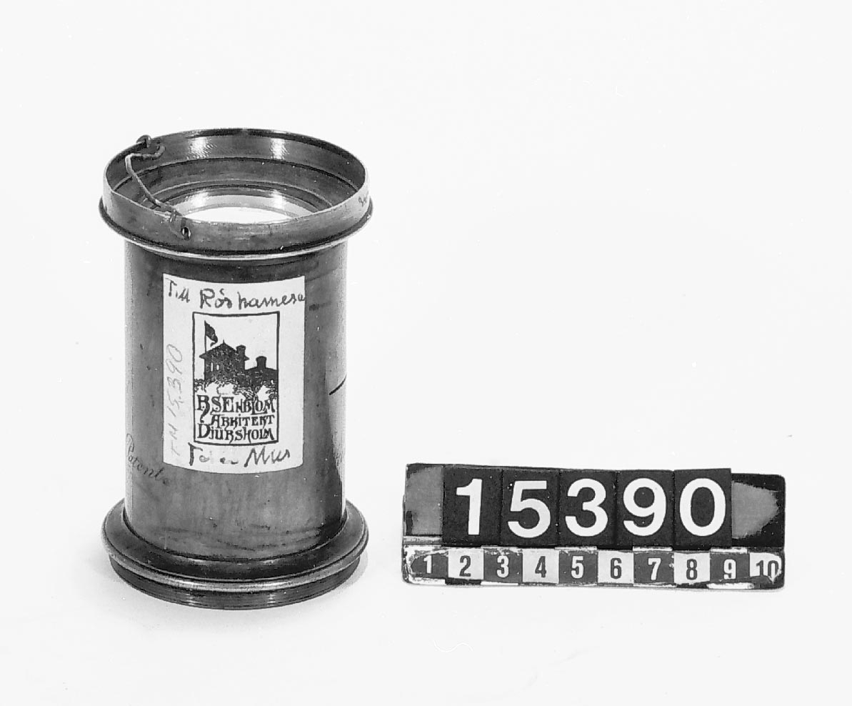 Amatörbygge, "tele". Rörkamera, för plåtar 90 x 120 mm, för fotografering av högt sittande detaljer på byggnader m.m. Lösa delar: kameran i 2 delar objektiv Steinheil 45 cm, nr 3431, pneumatisk slutare "le Toleb" nr 2785. Förbindelseringar av papp saknas. Kassetterna till kameran TM15389 har använts till denna apparat. Negativ taget med denna kamera: TM15391.
Tillbehör: Slutarmekanism.