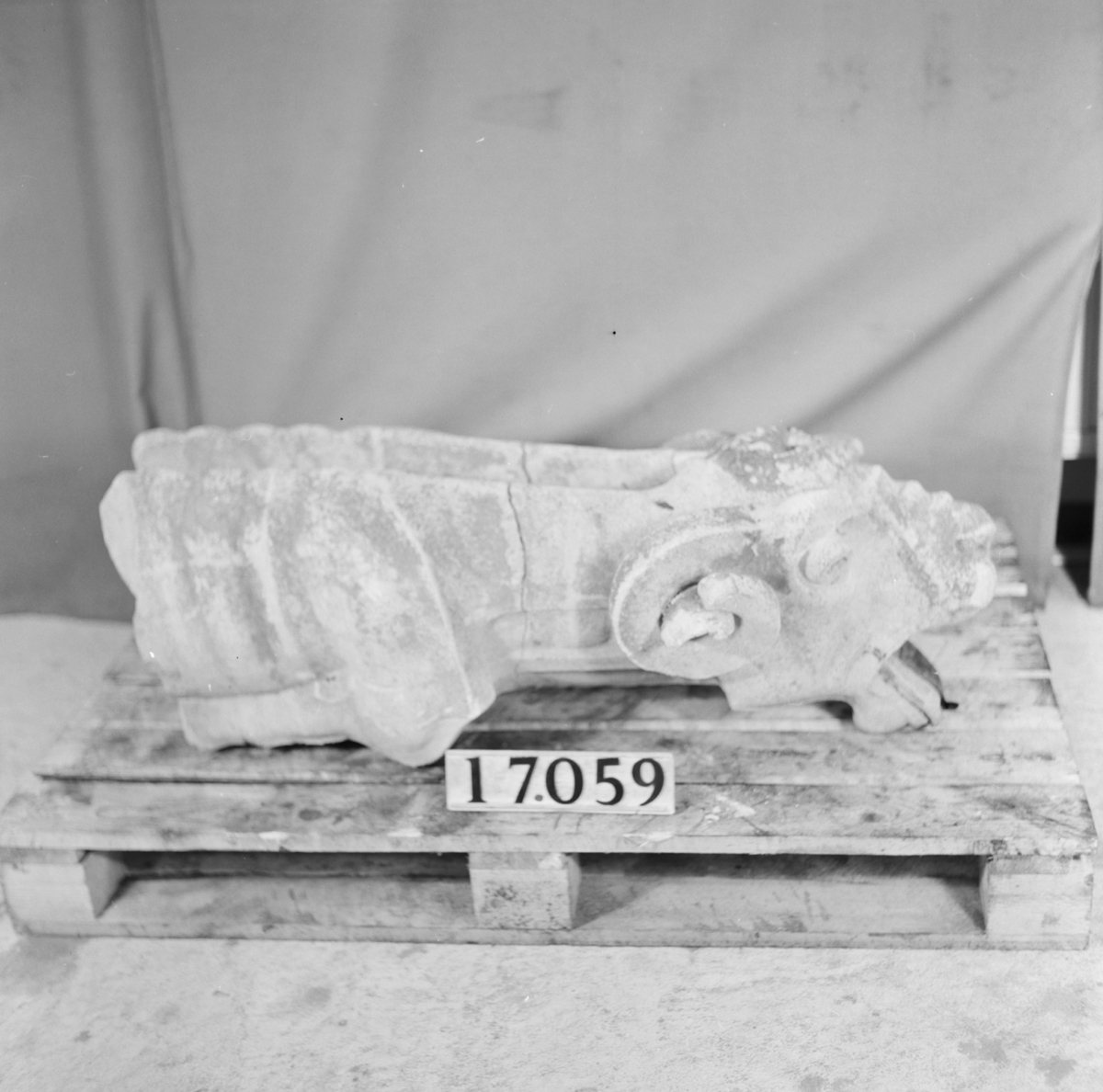 Fyra figurer av betong från den skulpturala utsmyckningen av Uppsala Domkyrka. Bl.a. slutstycke av takränna i form av groteskt djävulshuvud.