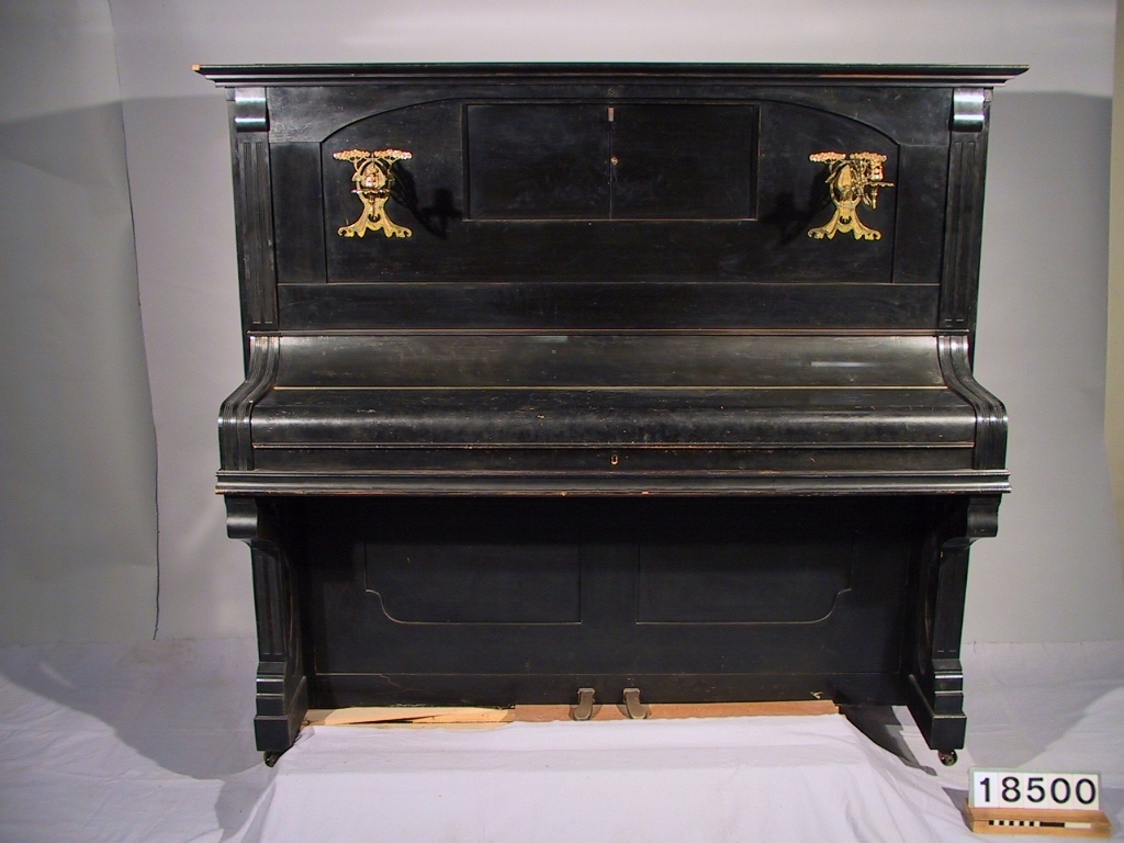 Elektriskt självspelande piano, "Melographpiano", för direkt inspelning och återgivning, jämte 5 s.t fonogramrullar. Motor: 220 v likström med inbyggd 12 v generator för elektromagneterna. Skylt: "Gleichstr. Type Fb N:r 14778 PS 1/6 Umdr. 1300 v 220 A..." Pådrag för max 1/4 hk.
Tillbehör: Lösa smådelar i en pappask från L.M.