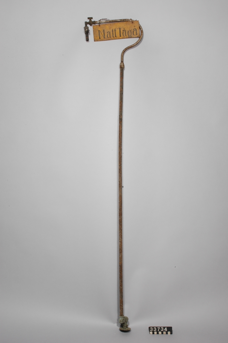 Består av 120 mm höga brännare för glödstrumpor och lampglas, monterade på 1300 mm långa rörarmar med vridbar förskruvning i övre änden.  Gul plåtskylt, text: Nattlåga.