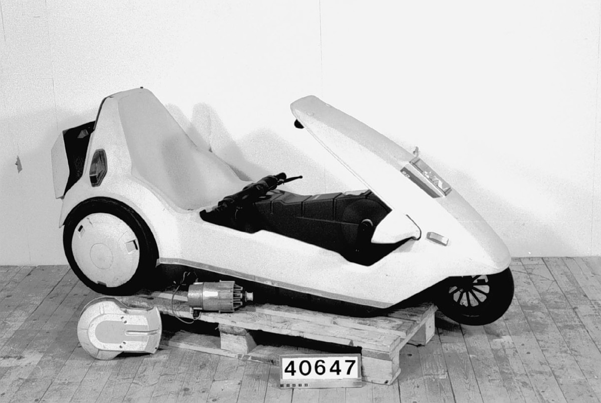 En trehjulig elektrisk moped konstruerad av Clive Sinclair. Hoover tvättmaskinsmotor driver bakhjulen. Batteri av typ mc- startbatteri. Kaross av gråvit plast.  Motor 12 volt, 259 Watt, 3300 varv per minut Körsträcka 2-3 mil.